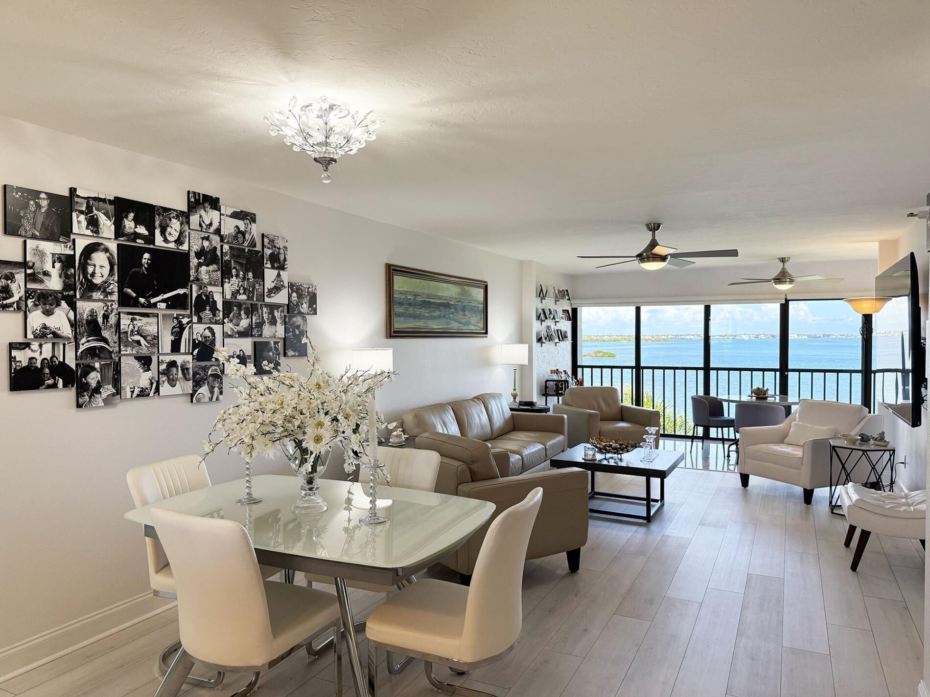 Uma sala espaçosa com mesa de jantar, sofás e varanda com vista para o mar.
