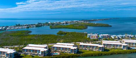 Um resort costeiro com vários edifícios, uma marina e águas azul-claras.