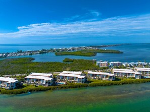 Ein Küstenort mit mehreren Gebäuden, einer Marina und klarem, blauem Wasser.