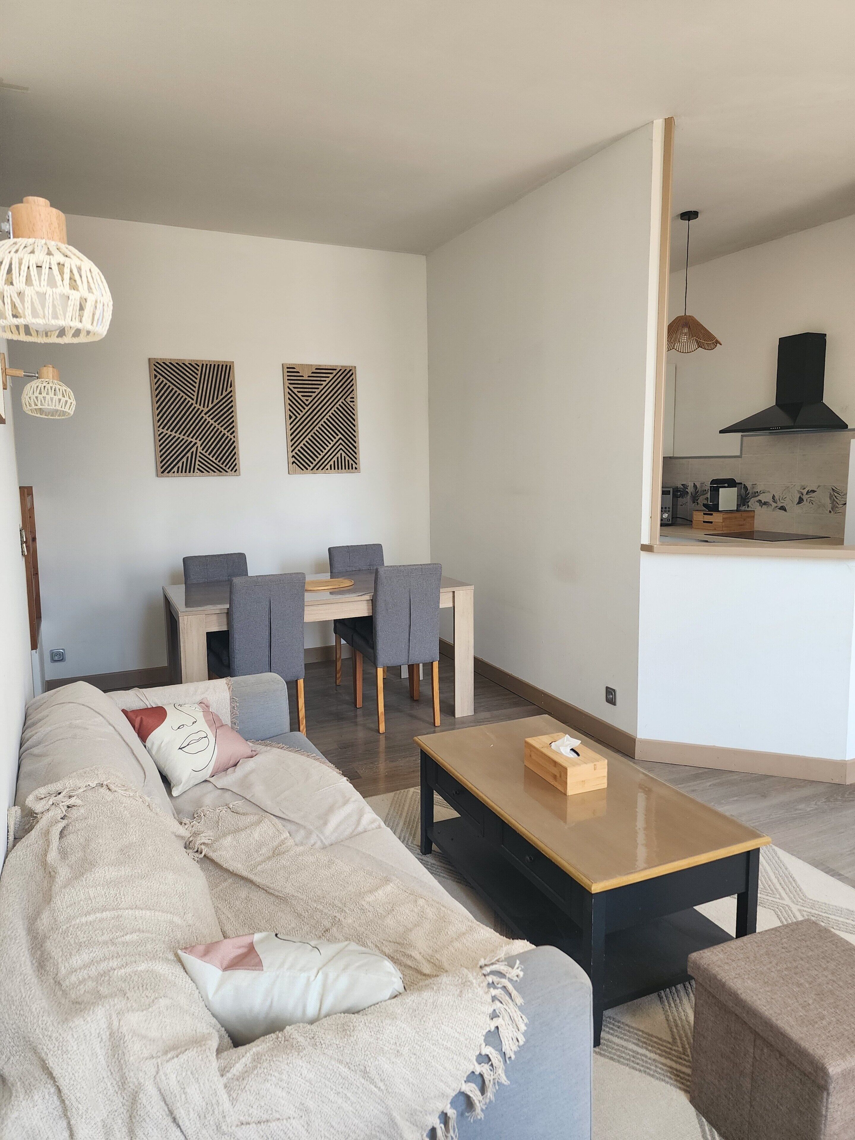 A modern living room with a sofa, coffee table, and dining area with chairs.