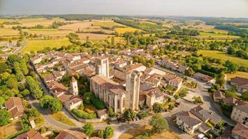 Luchtbeeld van een historische stad met een opvallende kerk, smalle straatjes en omliggende velden.