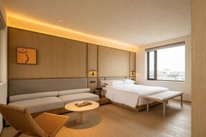 A modern hotel room with a bed, sofa, and a small table. - Yangzhou Guangling Youxiong Hotel (Yangzhou)