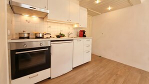 A kitchen with white cabinets, a stainless steel range hood, a dishwasher, and a red coffee machine. - Casa Cecilia Ascona 500m from the Lake, Ascona, Switzerland (Ascona)