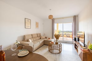 A modern living room with a sofa, a round coffee table, and a dining table with a wine glass. - Reserva De Marbella 2 Sunviews, Marbella, Spain (Marbella)