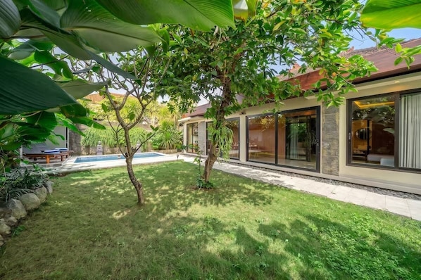 Ein modernes Haus mit Swimmingpool, großen Fenstern und einem gepflegten Garten.