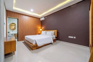 Ein modernes Hotelzimmer mit einem Holzbett, einem Nachttisch, einem Spiegel und einer wandmontierten Klimaanlage.