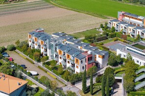 Ein moderner Wohnkomplex mit mehreren Wohngebäuden, einem zentralen Innenhof und umliegender Grünfläche.