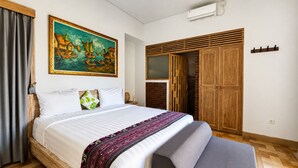 Un dormitorio con cama, un cuadro, un armario y una silla.