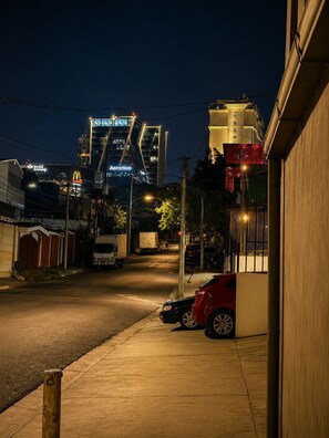 A nighttime urban street scene with buildings, parked cars, and a visible McDonald's sign.