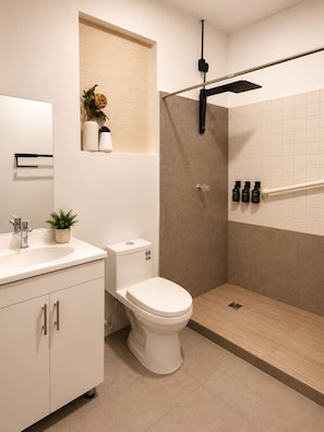 A modern bathroom with a toilet, sink, and shower.