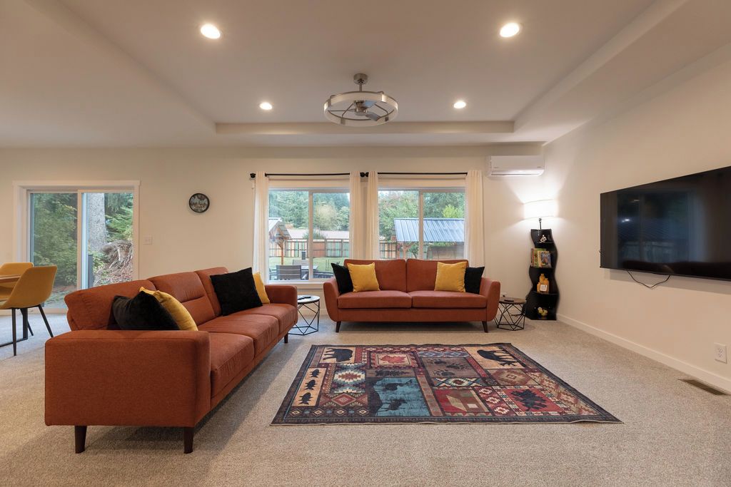 A living room with two sofas, a rug, and a TV.