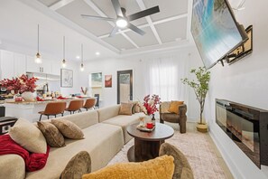 A modern living room with a sectional sofa, a coffee table, and a fireplace. - Near Med Center and NRG Stadium, Game Room, Fireplace (Houston)