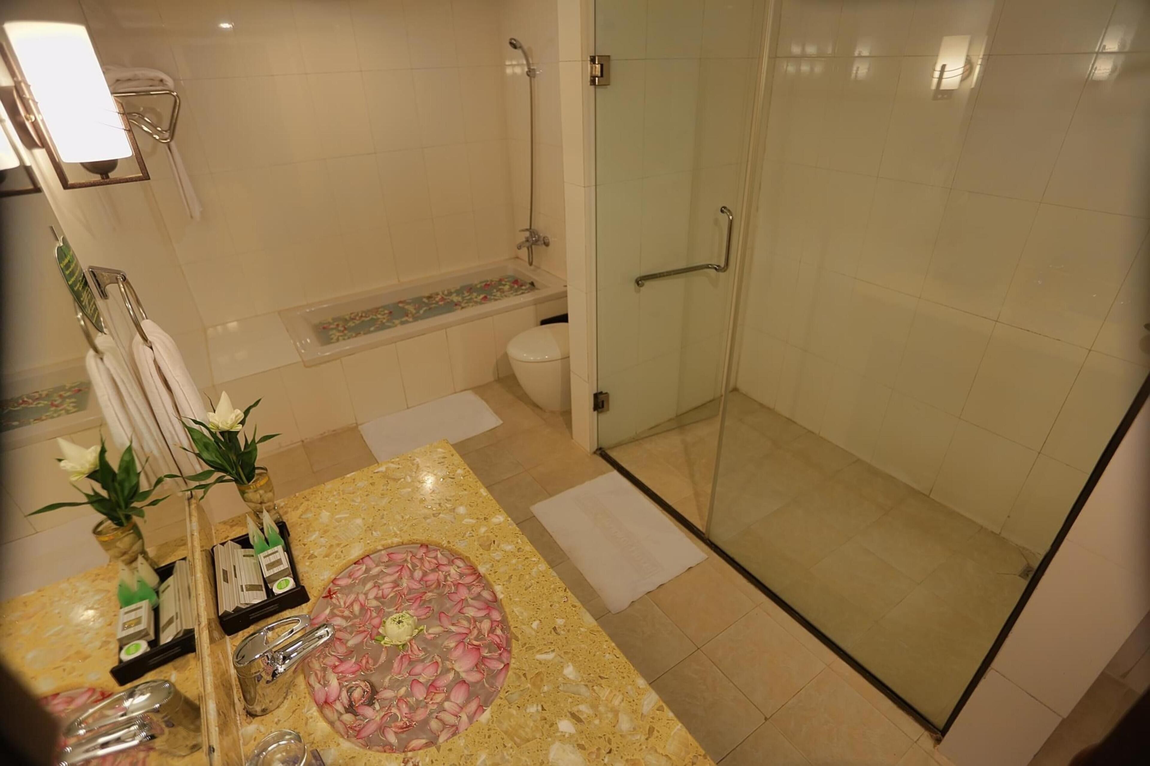 Executive suite, balkon, uitzicht op zwembad | Badkamer | Gratis toiletartikelen, een haardroger, badjassen, pantoffels