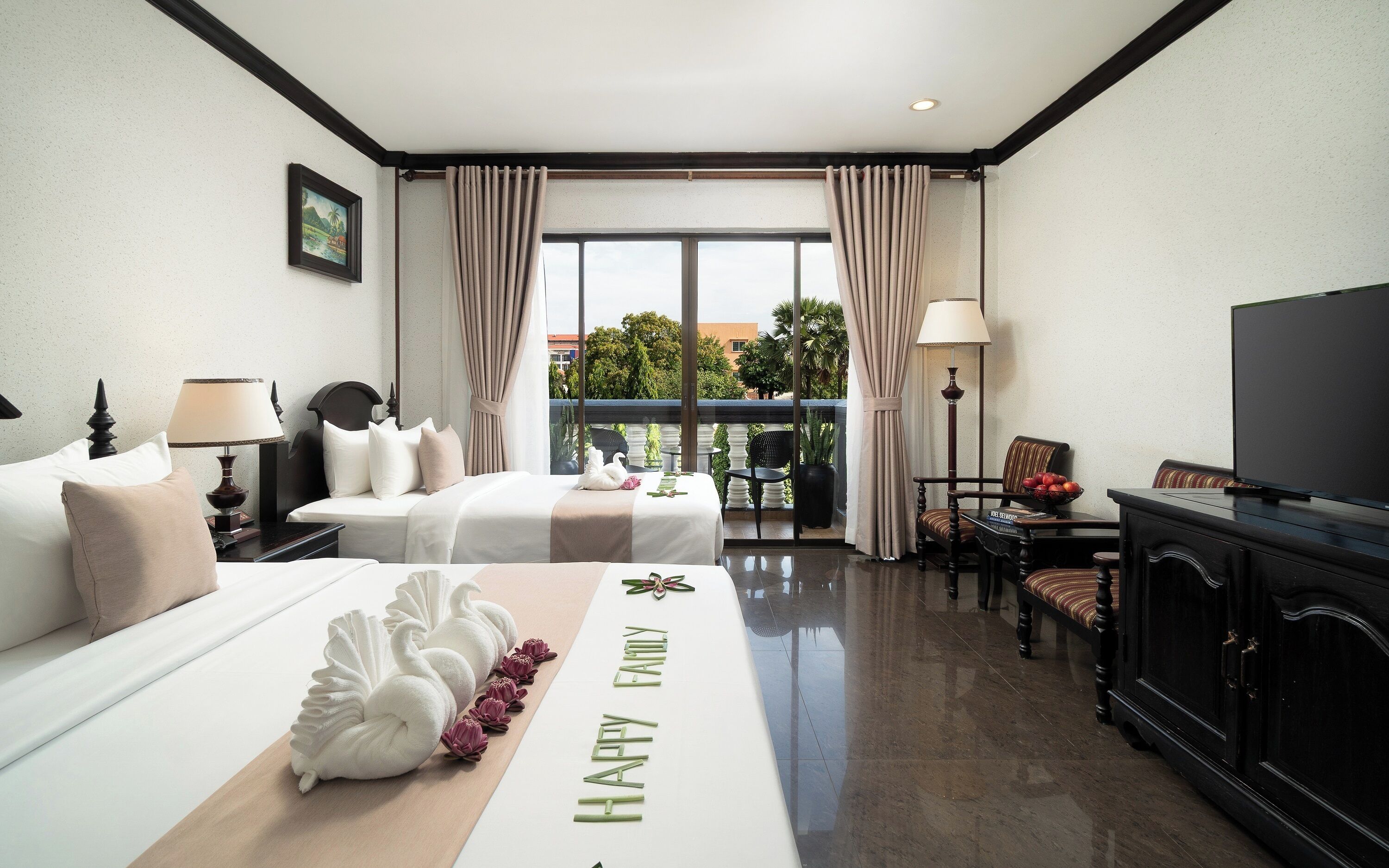 A hotel room with a bed, a desk, a television, and a view of the outdoors.