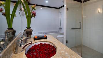 A modern bathroom with a marble sink, a glass shower enclosure, and a bathtub.