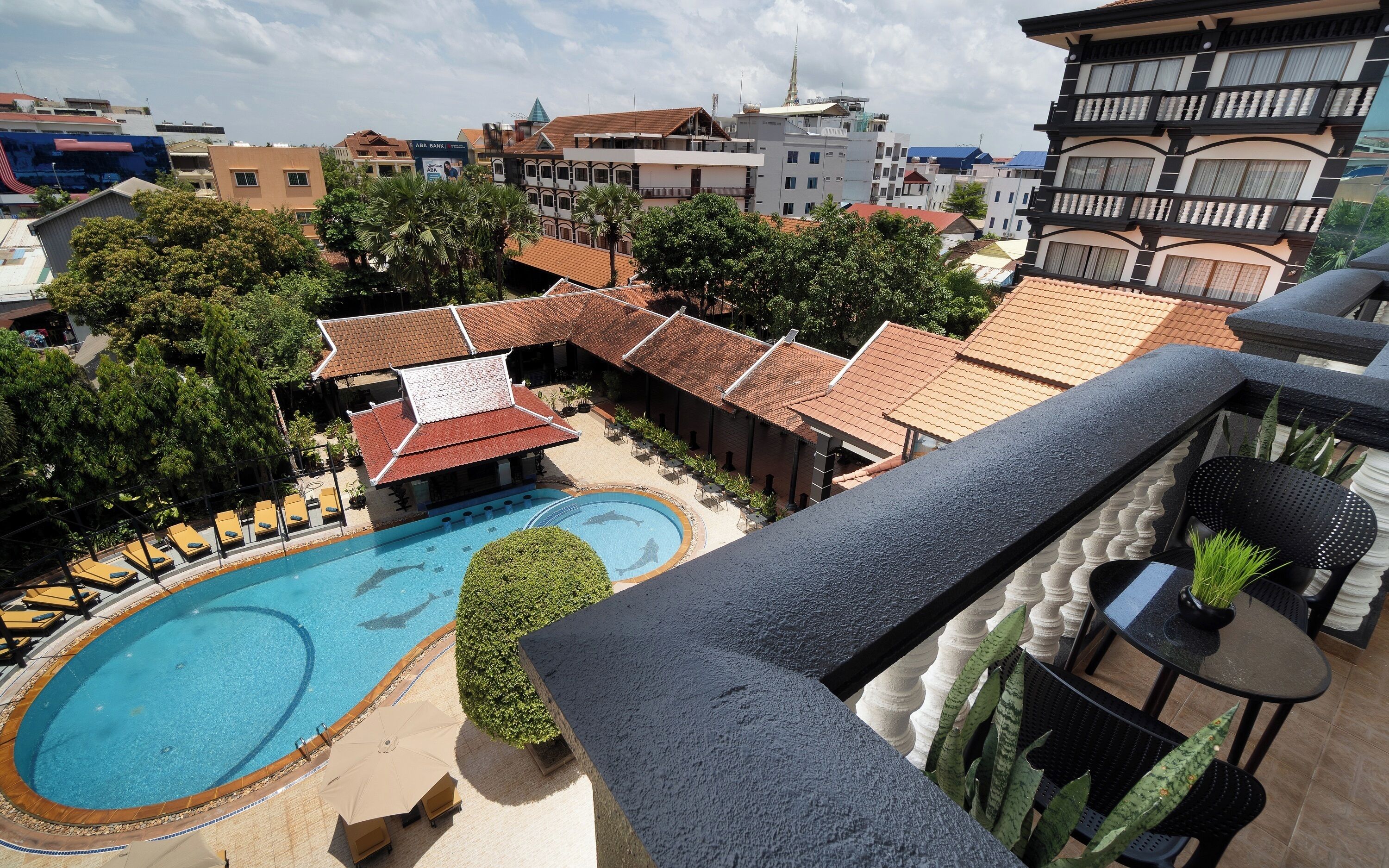 Un hotel con piscina, mobiliario exterior y vistas de los edificios circundantes.