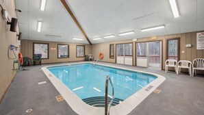 An indoor swimming pool with clear poolside areas, safety equipment, and exit signs. - Uncas by Avantstay Sleeps 7 + Bunk Room + 3 Baths Resort Pool + Game Room Gore Mountain (North Creek)