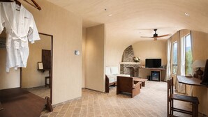 Amplia sala de estar con chimenea, televisión y comedor.