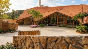 A building with a tiled roof, a stone wall, and a sign that reads 'CAMLY CAFE'. - Cam Ly The Boutique (Cam Ly - Da Lat)