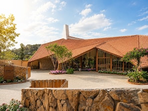 Um edifício com telhado de telhas, parede de pedra e uma placa com a inscrição 'CAMLY CAFE'.