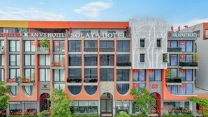 A hotel with multiple floors, balconies, and a prominent entrance. - Solaya hotel (Van Don)