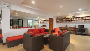 Un ambiente interno moderno con mobili in vimini, una libreria e una scrivania per computer.