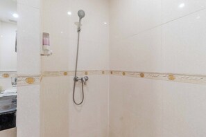Une salle de bain avec une douche, des toilettes et un lavabo.