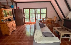 Ein gemütliches Zimmer mit einer Couch, einem Holzschrank und einem Kamin.