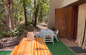 An outdoor seating area with a wooden table and chairs, surrounded by trees and a wooden fence. - 3 bedroom stunning home in Trecastagni (Trecastagni)