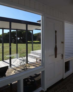 Ein überdachter Patio-Bereich mit einer Tür zu einem Außenbereich.
