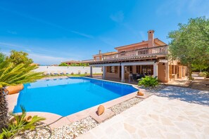 A poolside view of a Mediterranean-style villa with a swimming pool, outdoor seating, and a garden area. - MARINA BLAU - Fantastic villa with a private pool, just 5 minutes from the beach, with fre (Llucmajor)