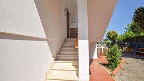 Escales que condueixen a una habitació amb una paret de maó i una porta.