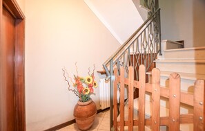 Eine Treppe mit hölzernem Geländer und Metallhandlauf, die zu einer oberen Etage führt.