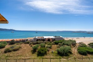 Küstensicht mit einem Gebäude, Strand und Booten.