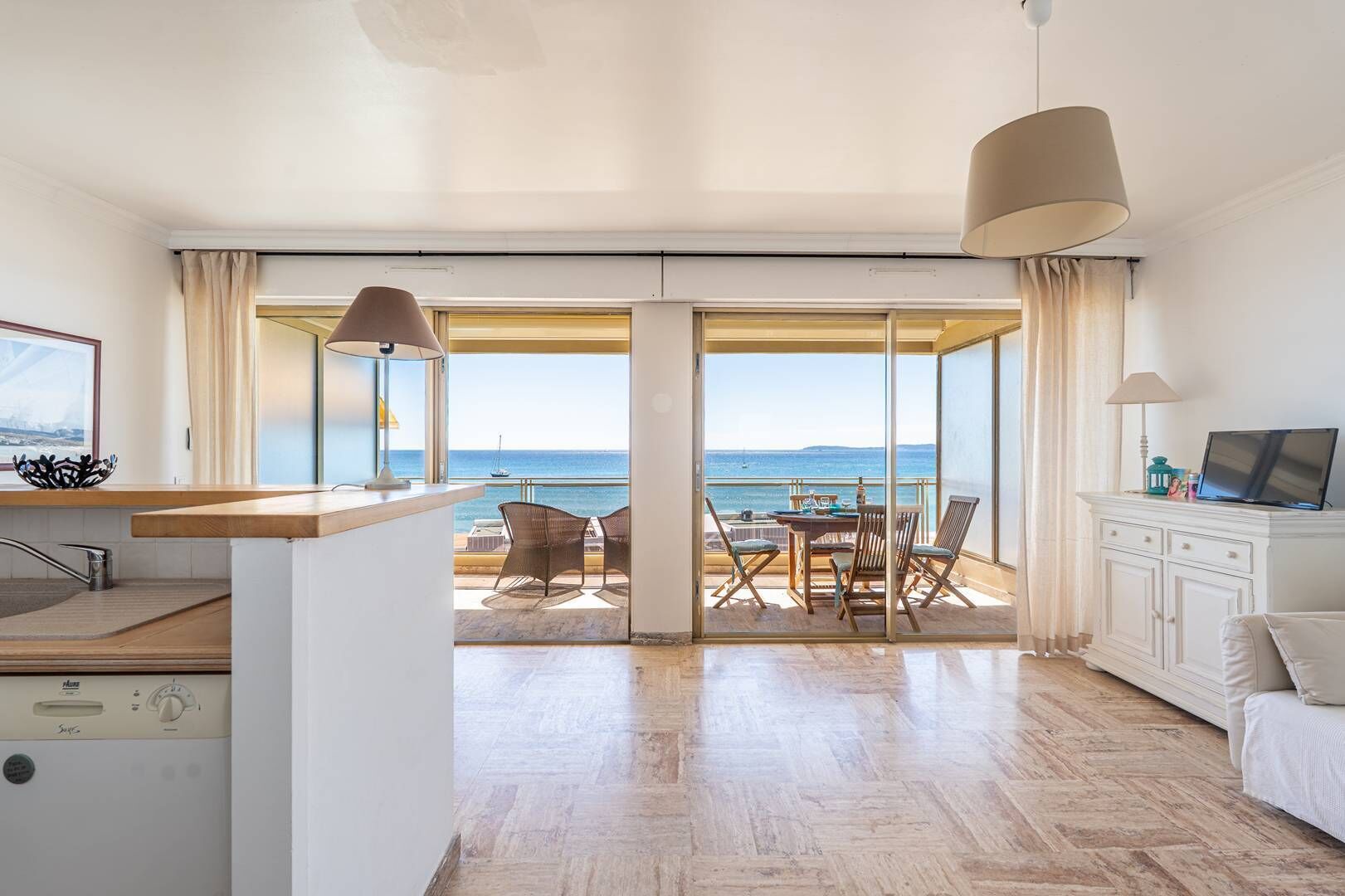 Ein modernes Zimmer mit Küche, Essbereich und einem Balkon mit Meerblick.