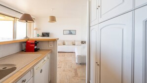 Eine moderne Küche mit einer Holz Arbeitsplatte, einem roten Gerät und einem Essbereich mit einem weißen Sofa.