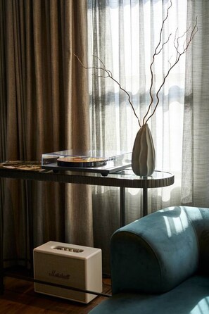 A room with a table holding a vinyl record player, a vase with branches, and a Marshall amplifier. - The Grand Heritage Suite · 4 Bed · Entire Floor (Auckland City)