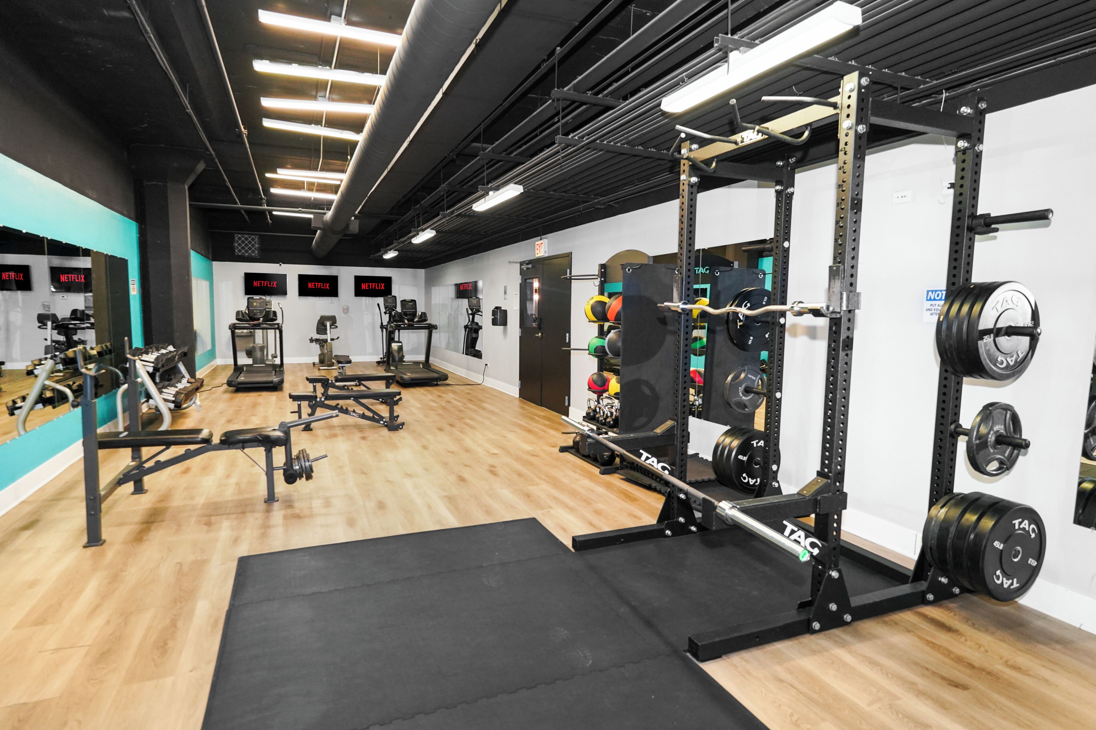 A gym with weightlifting equipment, treadmills, and exercise machines.