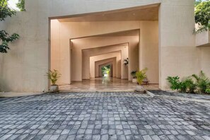 A paved entrance with a series of arches leading to a building.