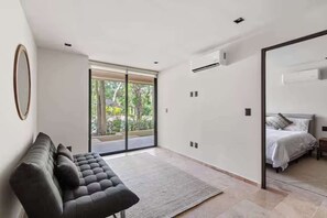Une chambre à coucher moderne avec un canapé, un lit et une grande fenêtre.