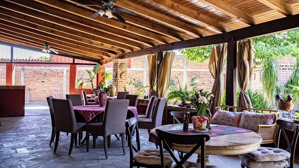 An outdoor patio with wooden beams, brick walls, and potted plants. - Natural refuge cabin in the Akron World Cup 2026 area (Jal.)
