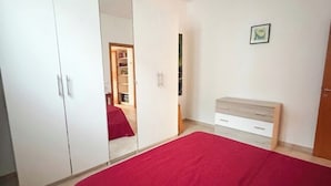 Ein Schlafzimmer mit Bett, Schrank und einem kleinen Nachttisch.