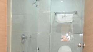 A modern bathroom with a glass-enclosed shower, a white sink, and a toilet. - The Aspire Hotel Guwahati (Guwahati)