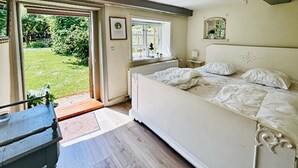 A bedroom with a bed, a window, a radiator, and a door leading to a garden. - 6 bedroom gorgeous home in Ribe (Ribe)