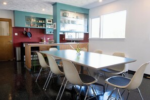 A modern kitchen with a dining area, including a table and chairs, and a window providing natural light.