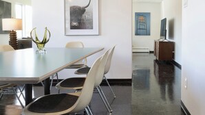 A conference room with a long table, four chairs, a vase, and a framed picture on the wall. - Serene 2-bedroom bed & breakfast in Anchorage welcomes you (Anchorage)