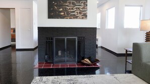A spacious living room with a fireplace, a large abstract painting, and a modern sofa. - Serene 2-bedroom bed & breakfast in Anchorage welcomes you (Anchorage)