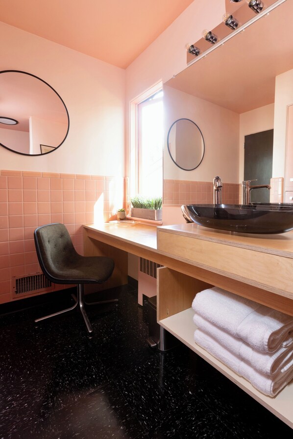 A bathroom with a black sink, a chair, a towel rack, and a mirror. - Serene 2-bedroom bed & breakfast in Anchorage welcomes you (Anchorage)