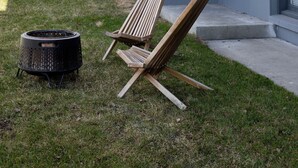 A house with a flag, a chair, and a grill in the yard. - Serene 2-bedroom bed & breakfast in Anchorage welcomes you (Anchorage)