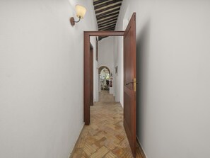 A hallway with a wooden door, a light fixture, and a tiled floor. - Quinta da Luz, Rustic Villa with Pool and Sea Views (Luz, Lagos)